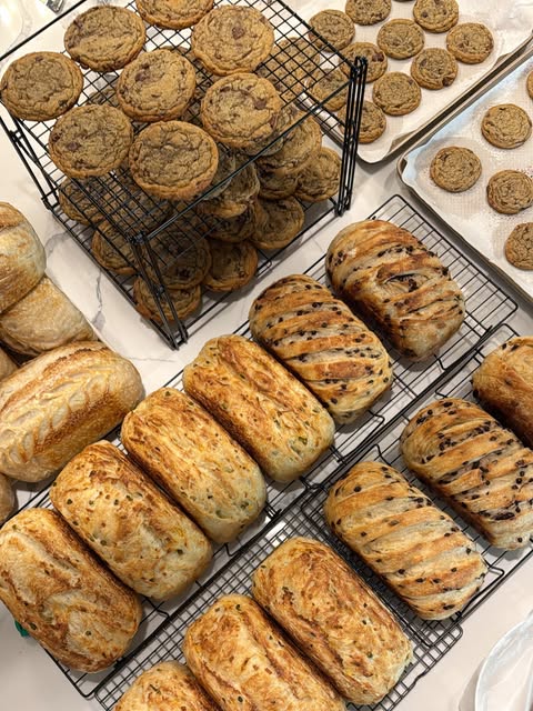 Sourdough loaves and cookies cooling on racks.